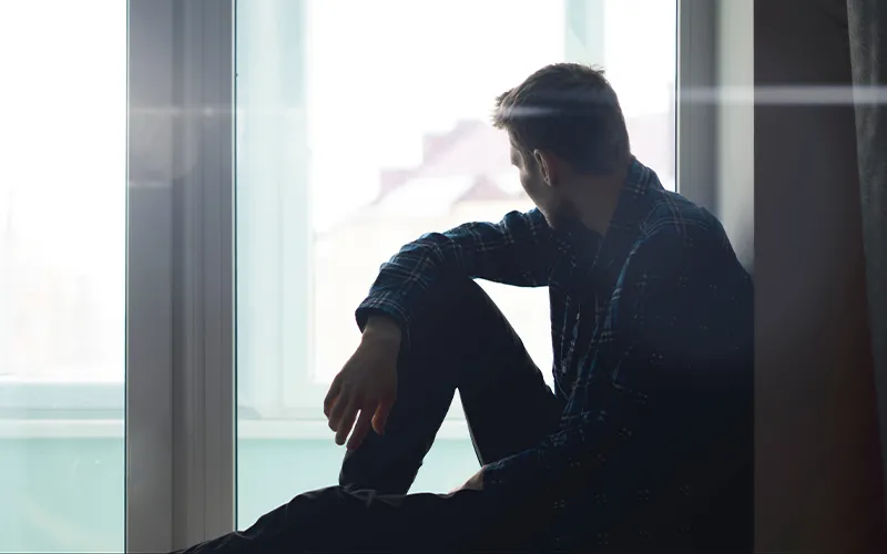 Person sitting and looking out of large window