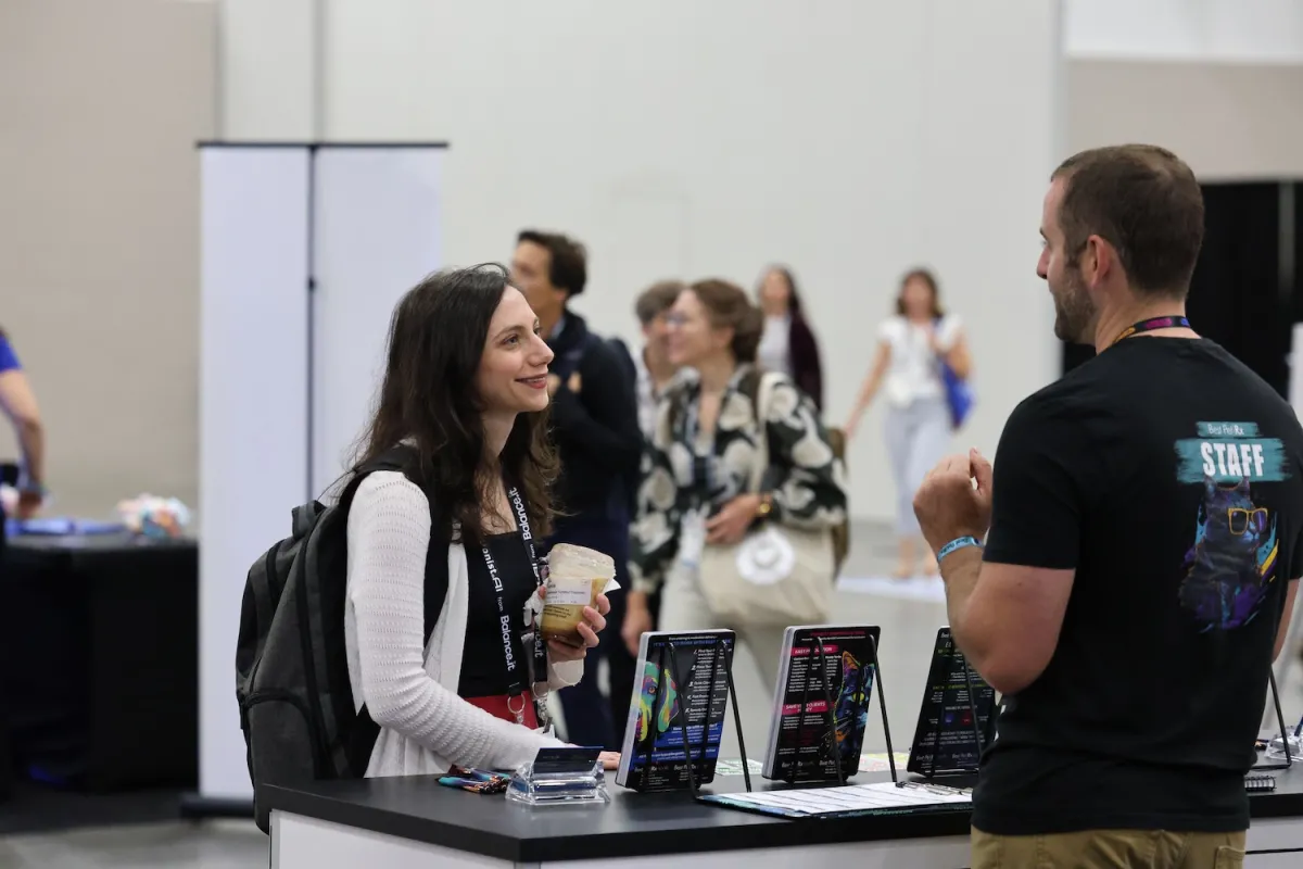 Attendee talking to exhibitor at booth