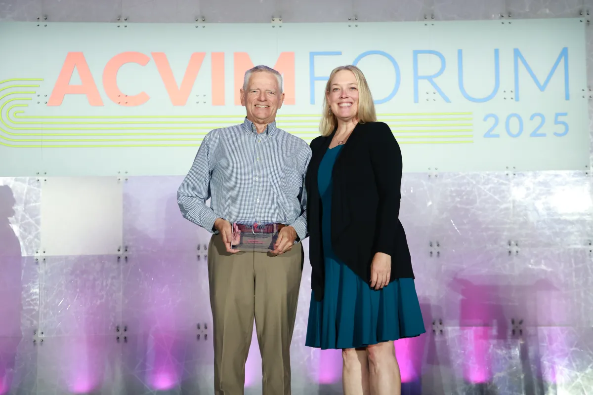 man and woman on stage with an award