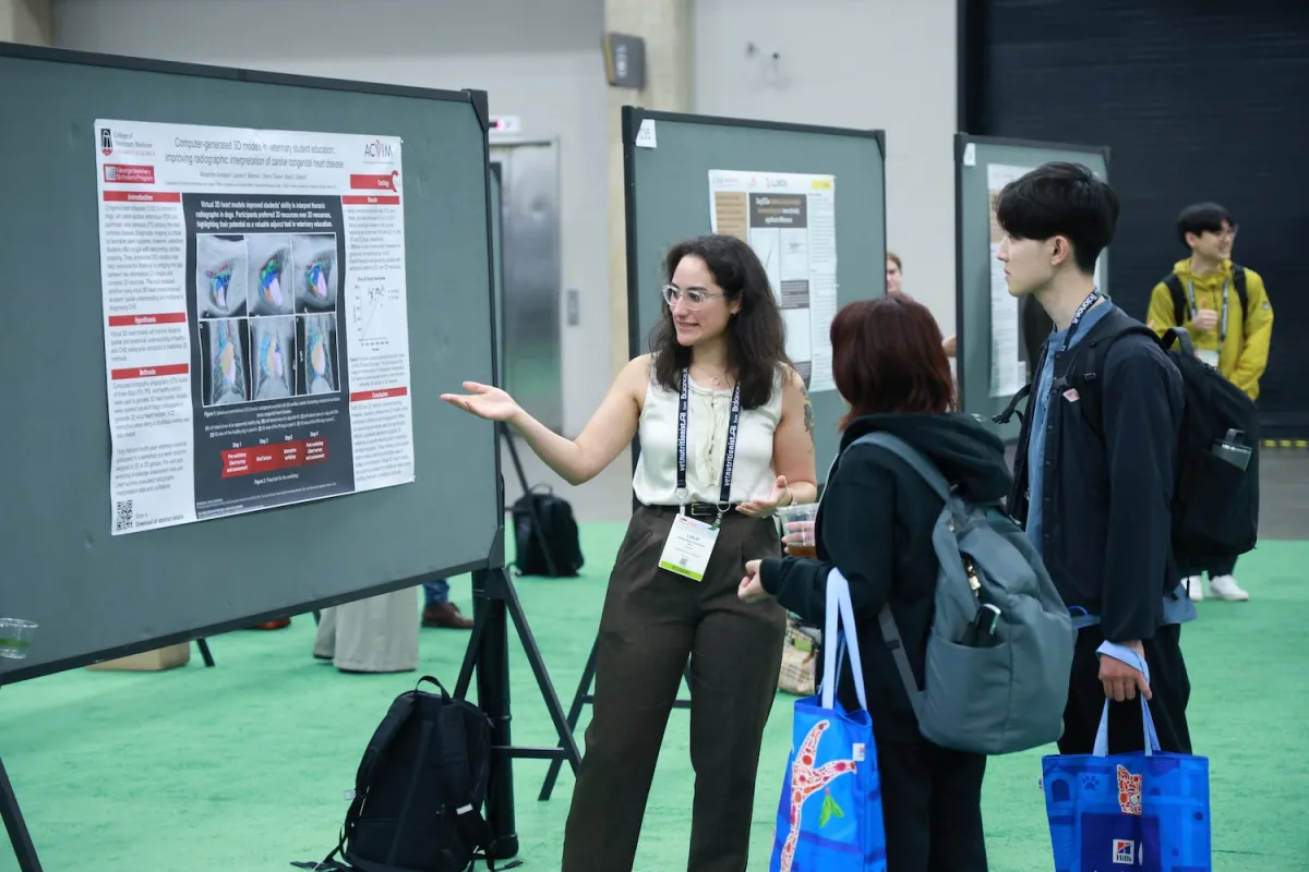 Presenter in poster park explaing poster to attendees