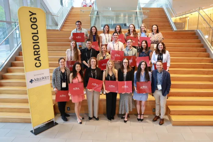 New diplomates in from of sponsor sign