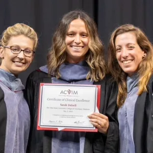 Three People with one holding a certificate