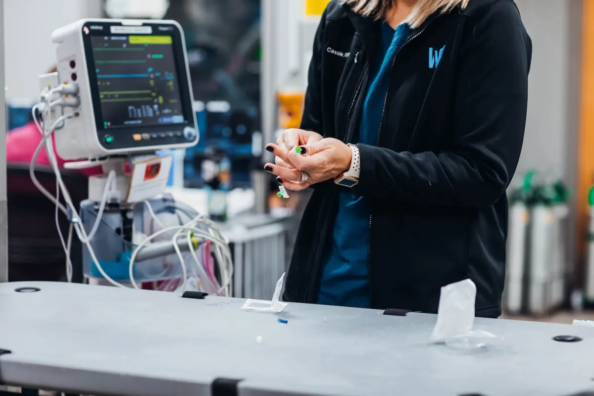 a person with a needle in front of veterinary equipment