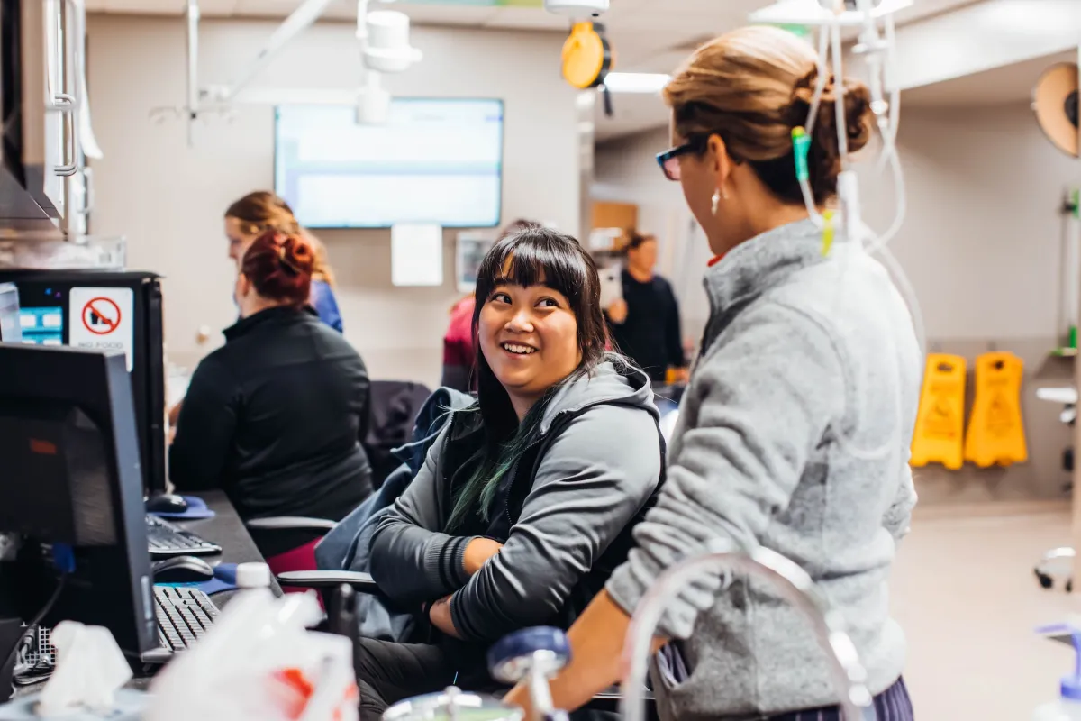 two people talking at computer