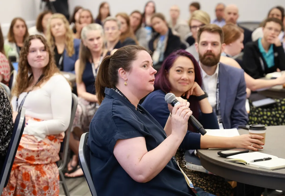 Attendee in audience speaking into microphone
