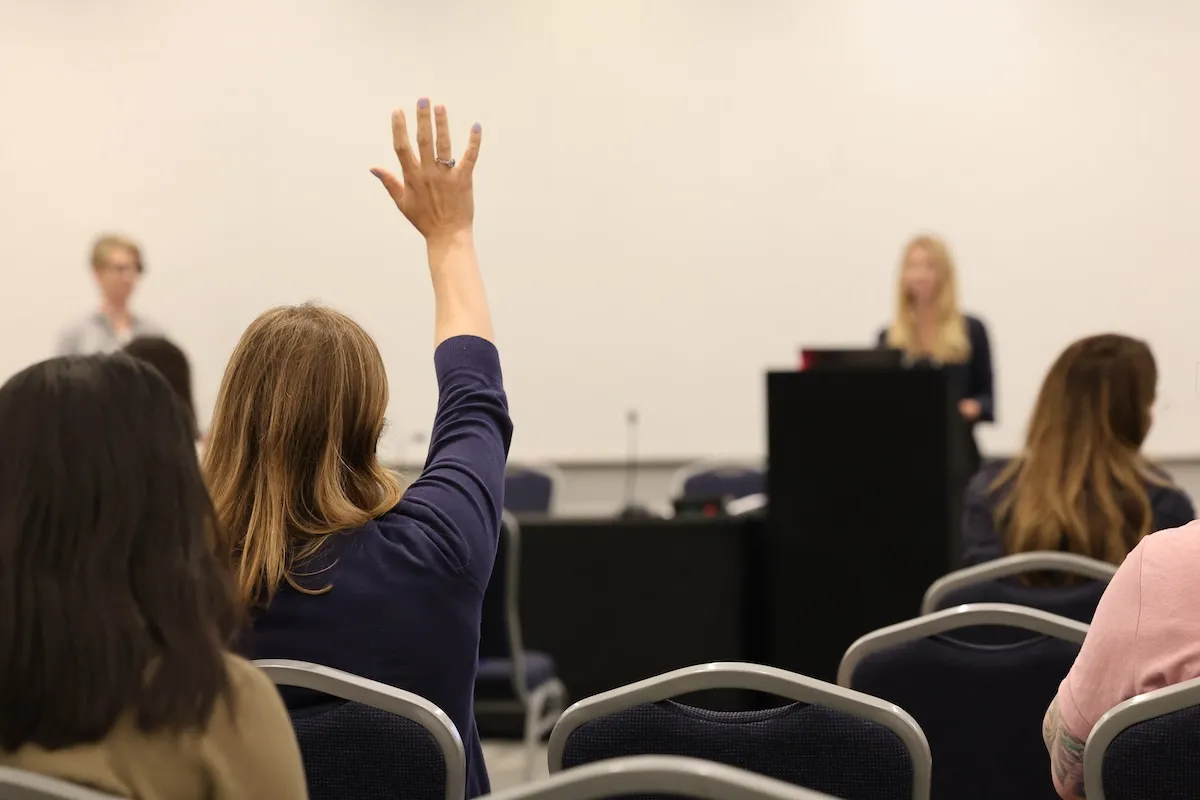 Attendee raising hand in session