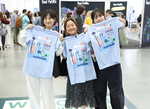 3 attendees holding up tshirts
