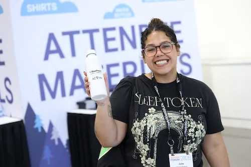 Attendee holding water bottle smiling