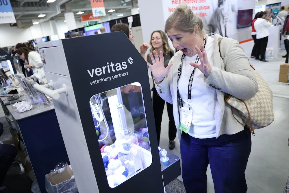 Attendee excited at claw machine in exhibit hall