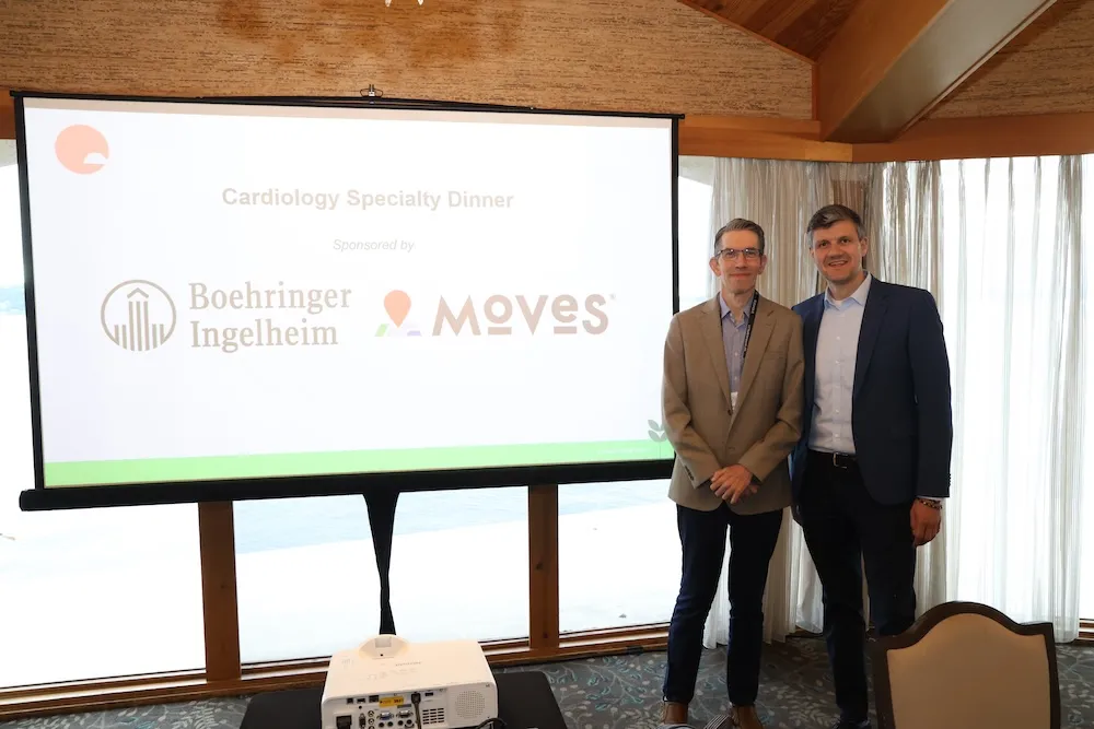 Two sponsors in front of slide with their logos