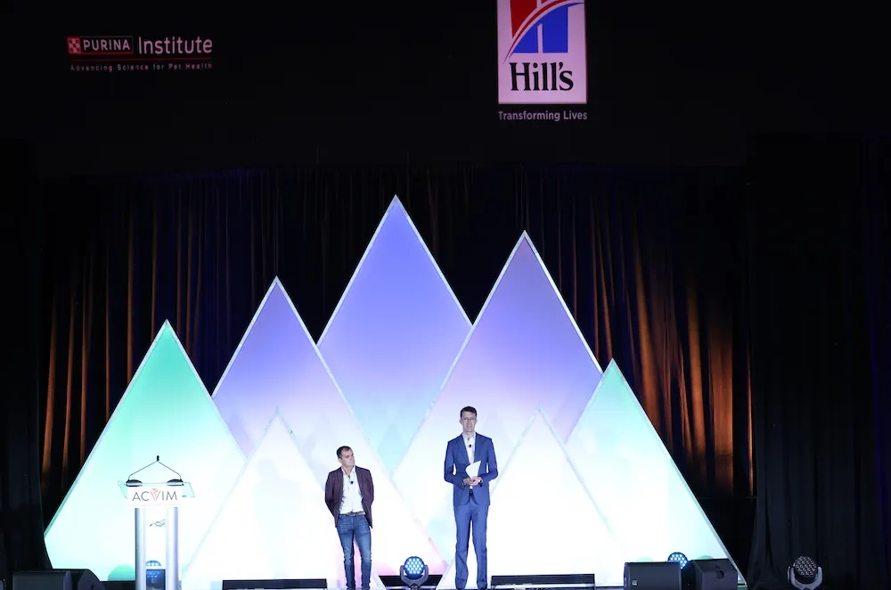 two speakers in front of mountain backdrop at general session
