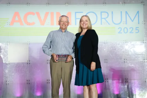 Warwick Bayly accepts the LAIM Specialty Lifetime Achievement Award from Dr. Sandy Taylor at the 2025 ACVIM Forum
