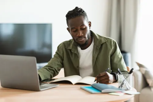 Man taking notes in front of computer