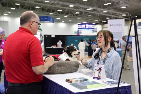 Attendee talking to exhibitor at booth