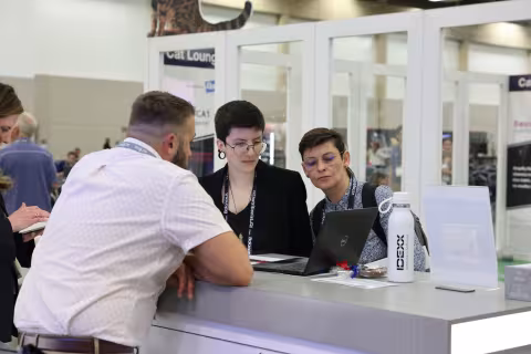 Attendees looking at screen at exhibitor booth