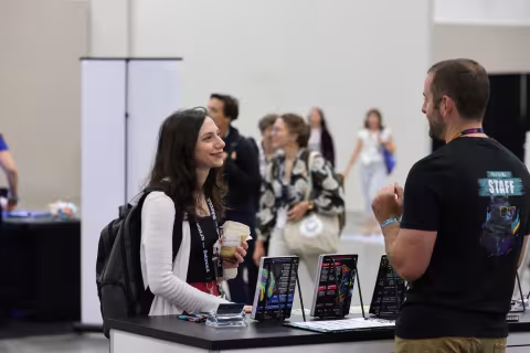Attendee talking to exhibitor at booth