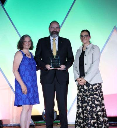 Sarah Gillings, Chris Fulkerson, and Cameon Ohmes pose on stage during the 2026 ACVIM Awards Ceremony